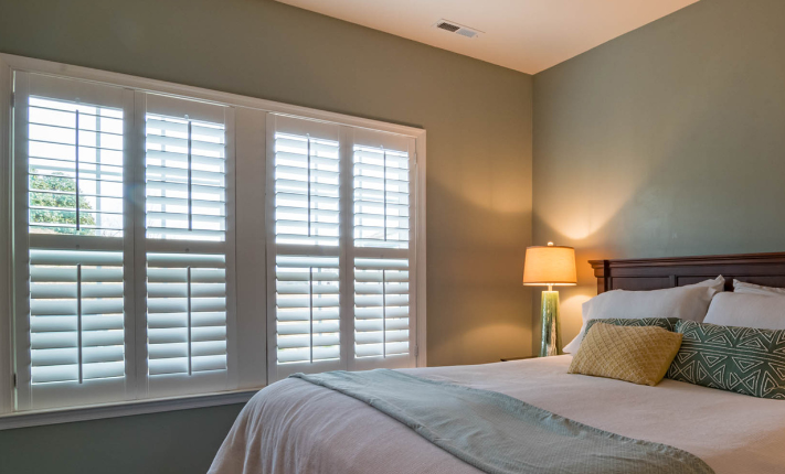 Windows with blinds in a bedroom. 