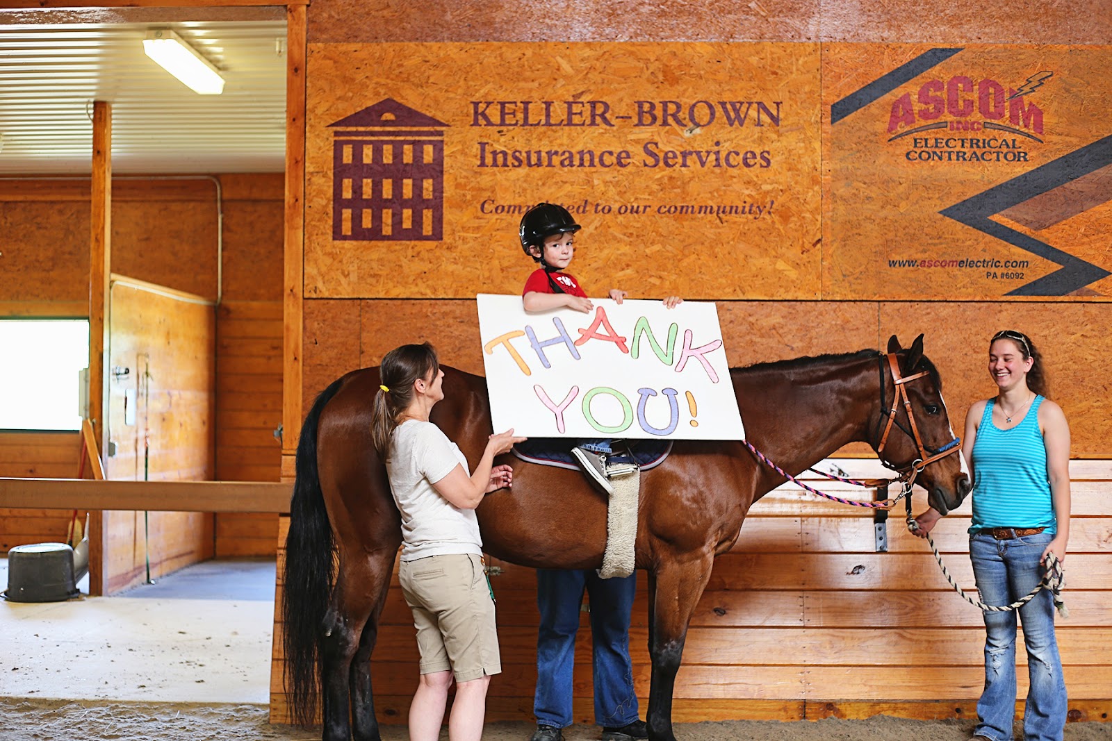 Photo of boy on horse, with family and a Thank You sign