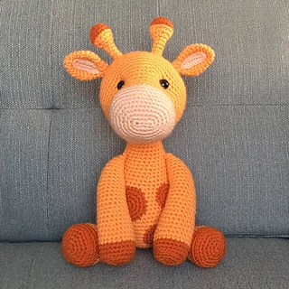 crochet giraffe sitting on couch