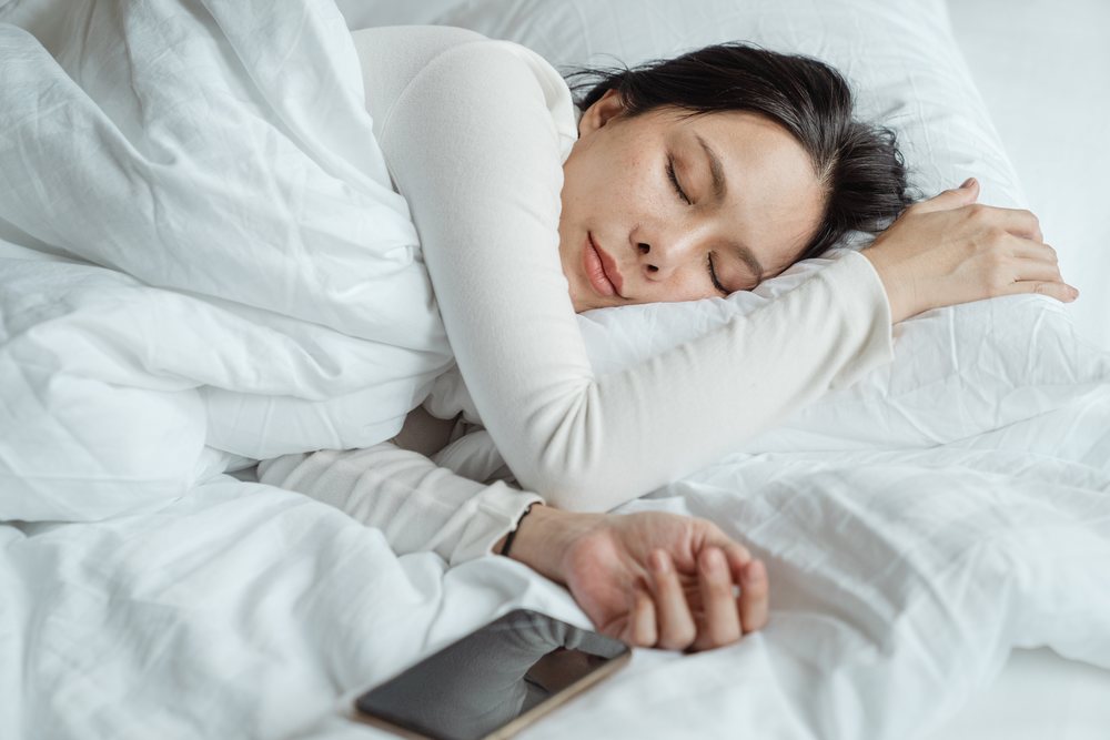 Woman sleeping on white bed
