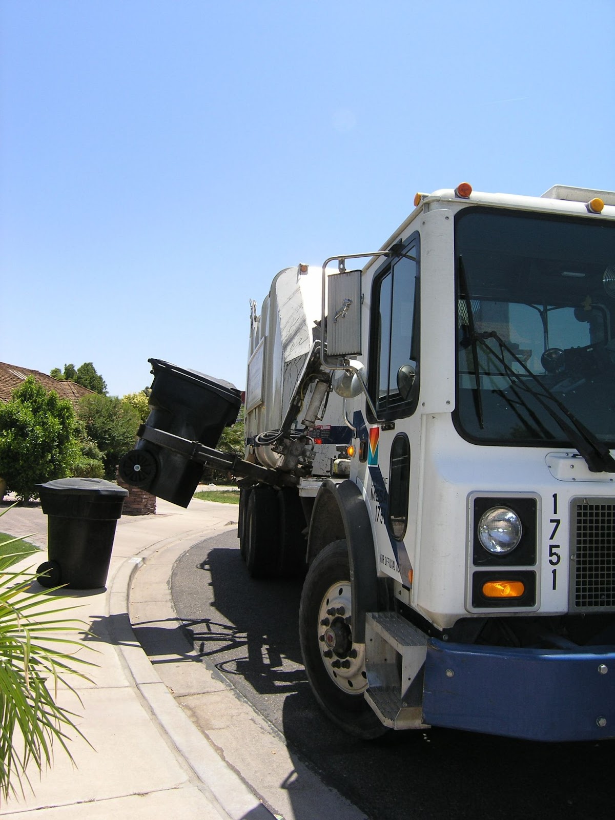 White garbage truck picking up rubbish