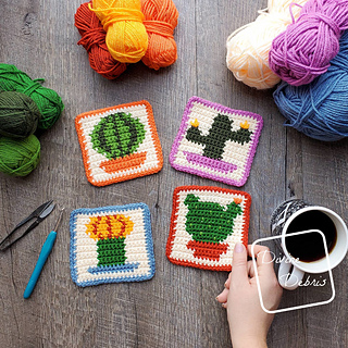 set of four crochet cactus coasters on wooden table