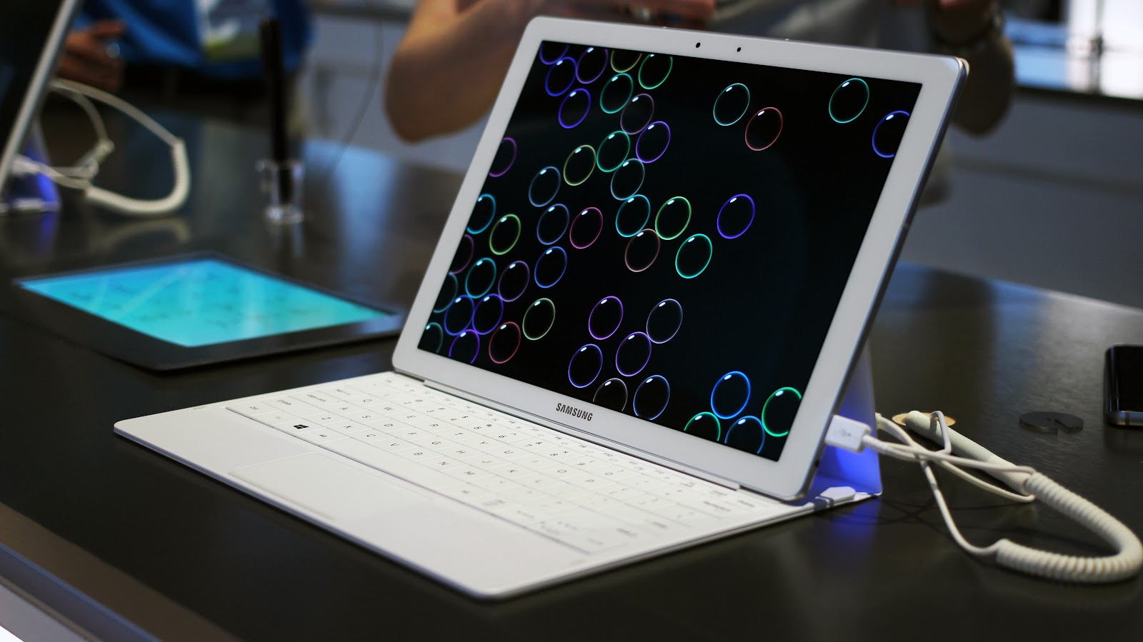 This image shows the white Samsung Galaxy Book 2 Pro 360 in the black table.