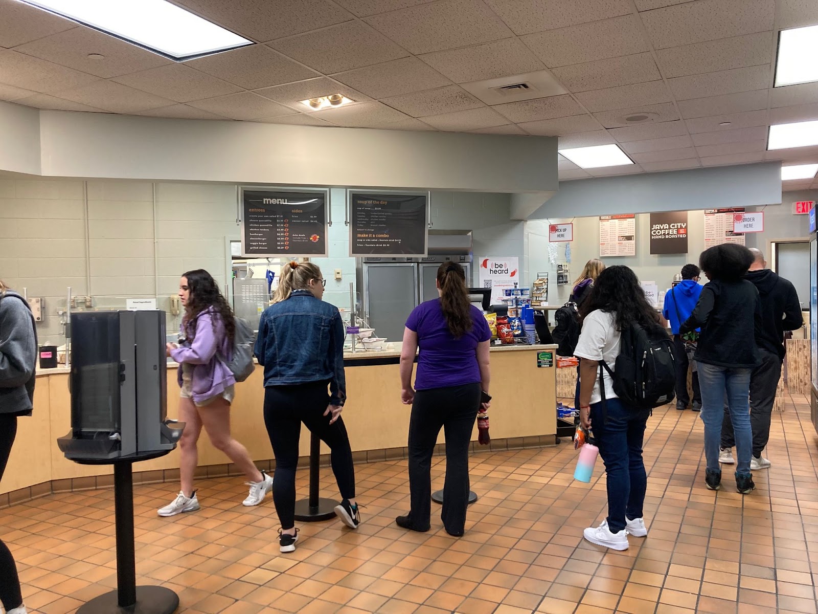 photo of 8 students at the Corner Bistro cafe, waiting in line and picking up orders