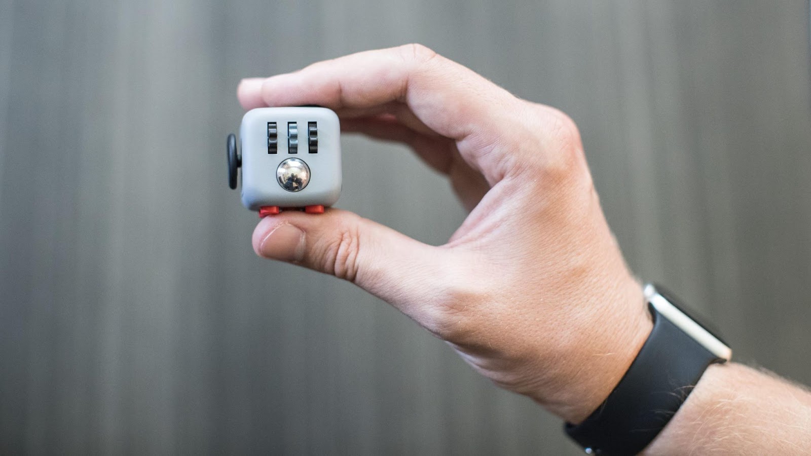 A hand holding a fidget cube office toy