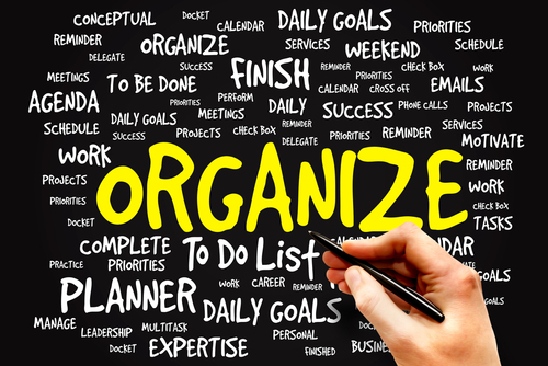 a word graphic centered on the word organize in bright yellow letter with other related words in white on a black background