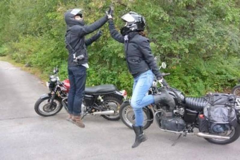 Motorcyclists celebrate epic ride with a high five gesture