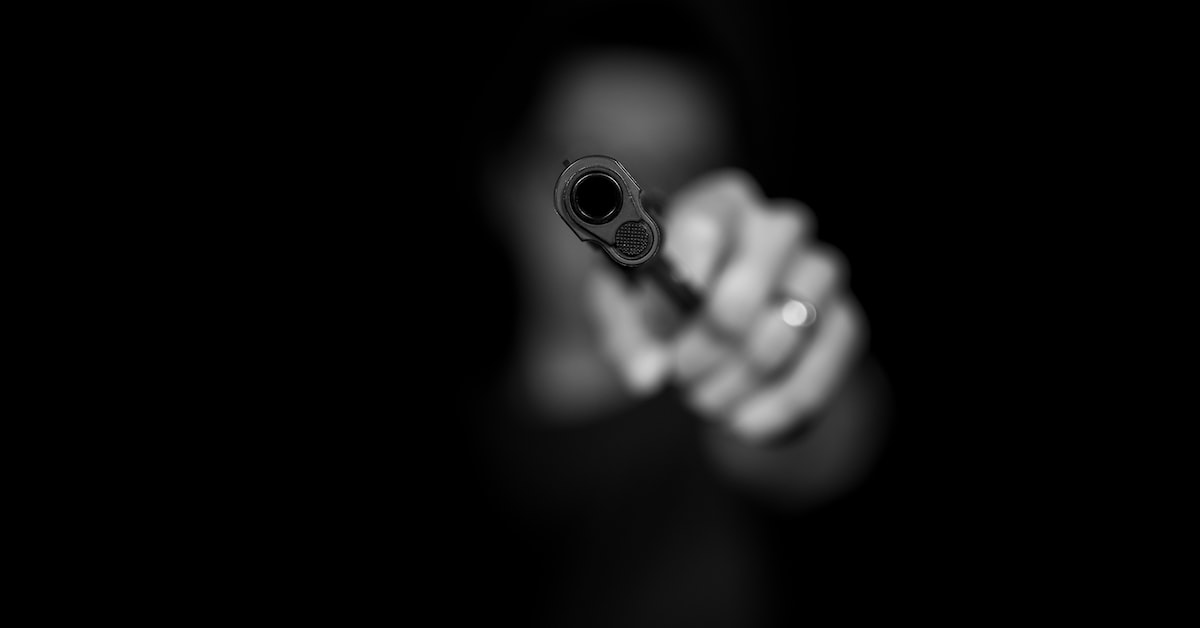 Man holding a gun on a black background