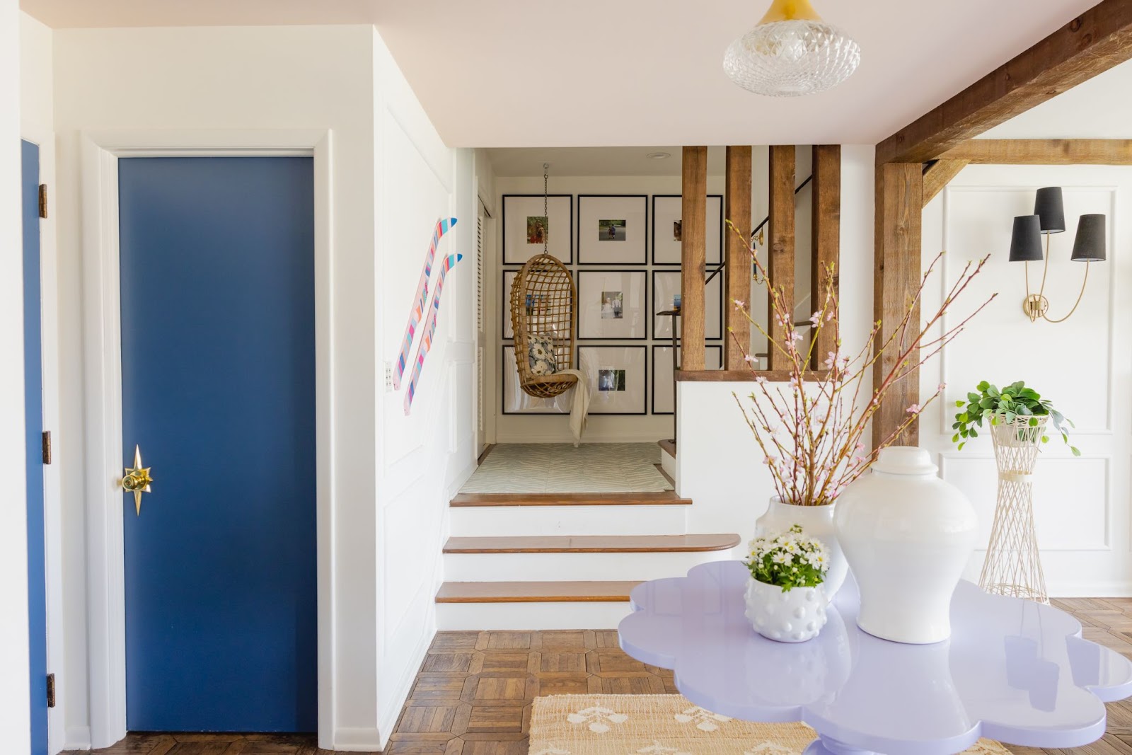 A designed space with neutral/pastel furniture with a touch of colorful, whimsical decorative pieces on the wall and a cobalt blue painted door.