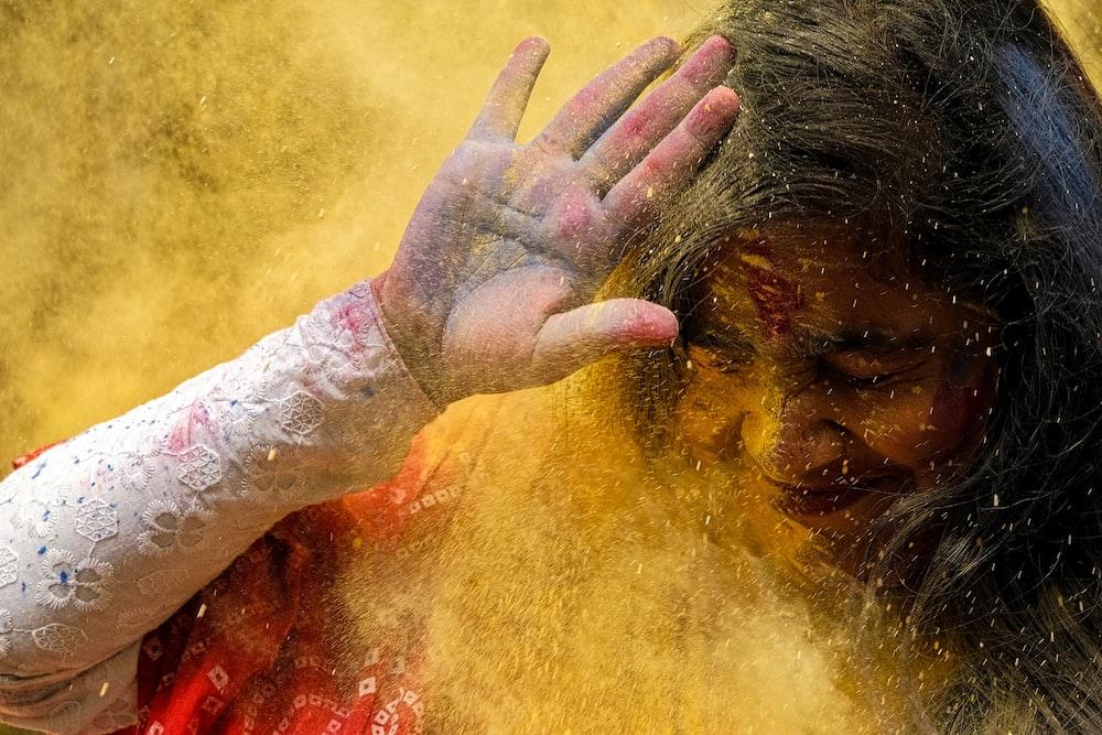 woman in red shirt with hand on face