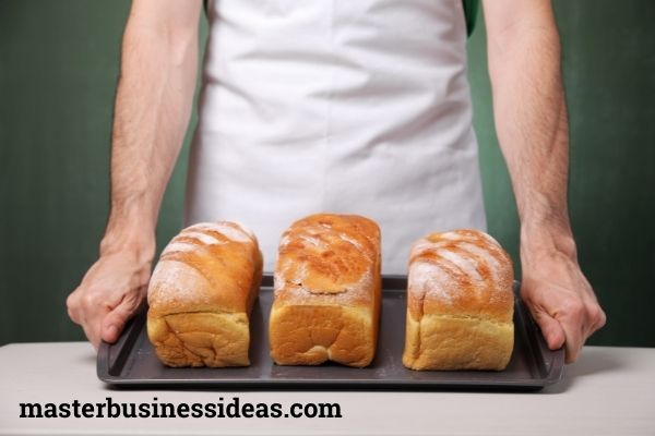 bakery items in a tray, and a man is holding it.