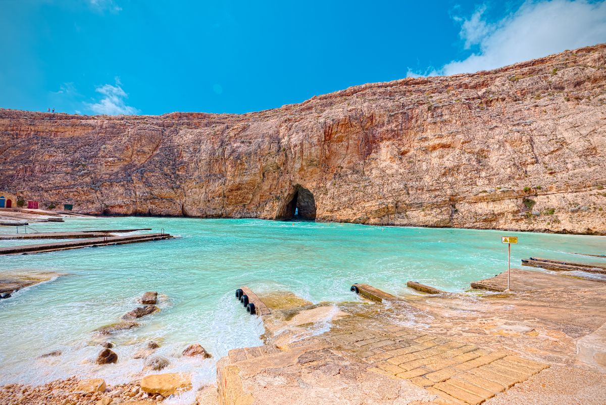 A cove in Malta with the towering limestone rock formations that line the island.