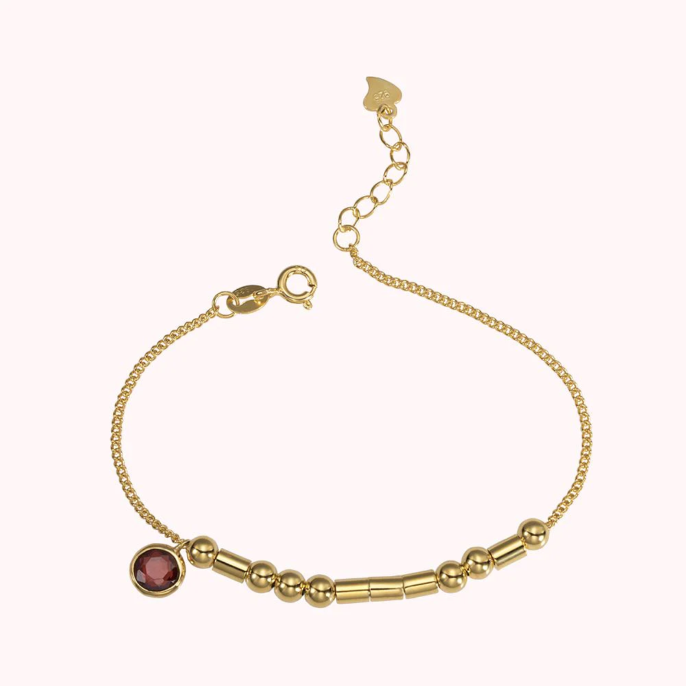 bracelet en or avec pierre de naissance, personnalisé par un message codé en morse grâce à une succession de perles et de cylindres.