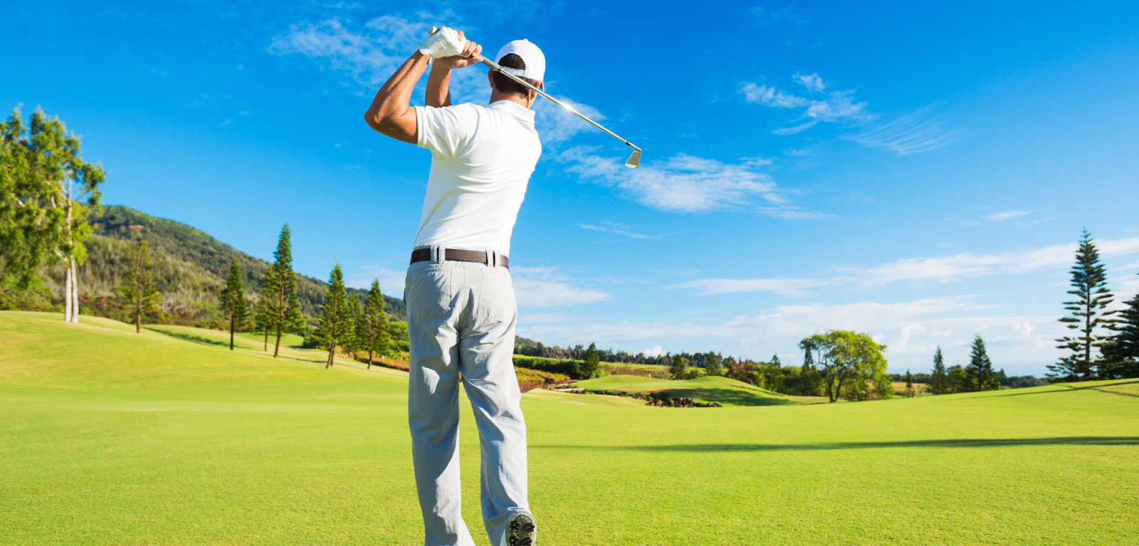 Man striking golf ball on beautiful golf course