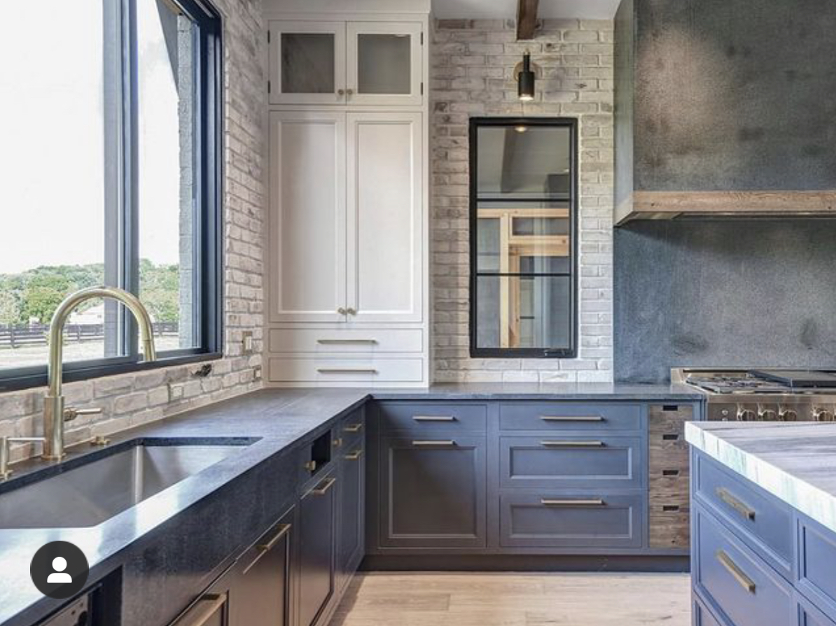 dark blue kitchen with brick accents