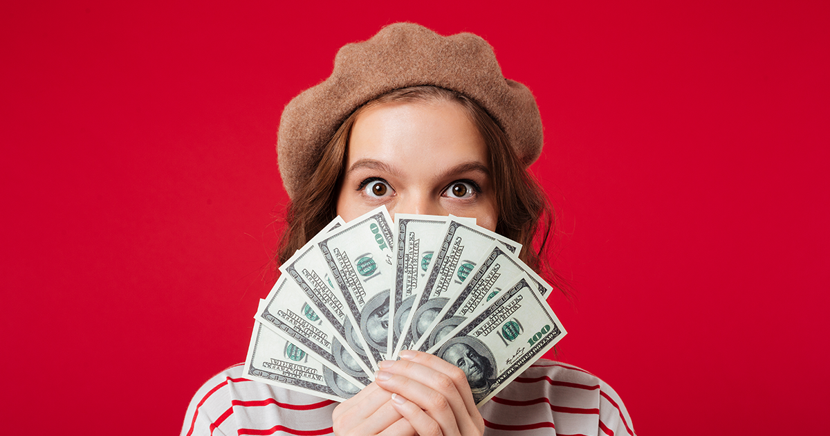 girl holding money in front of her face