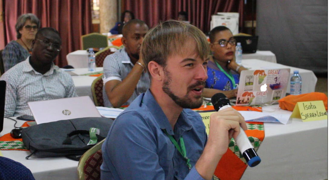 A participant speaks into a microphone during the course