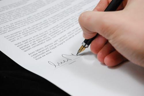 Free Person Signing in Documentation Paper Stock Photo