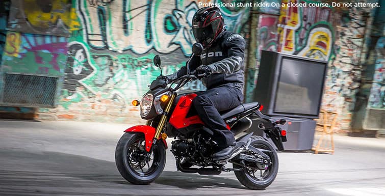 Motorcyclist passing vibrant graffiti wall - urban adventure on two wheels