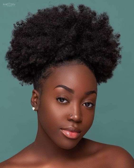 a gorgeous black lady wearing afro puff for styling natural short hair