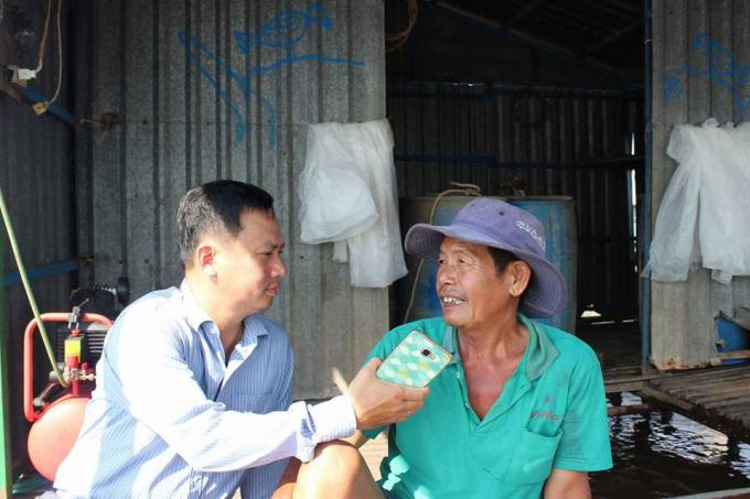 Nhà báo Nguyễn Chu Trinh phỏng vấn người dân khi tác nghiệp.
