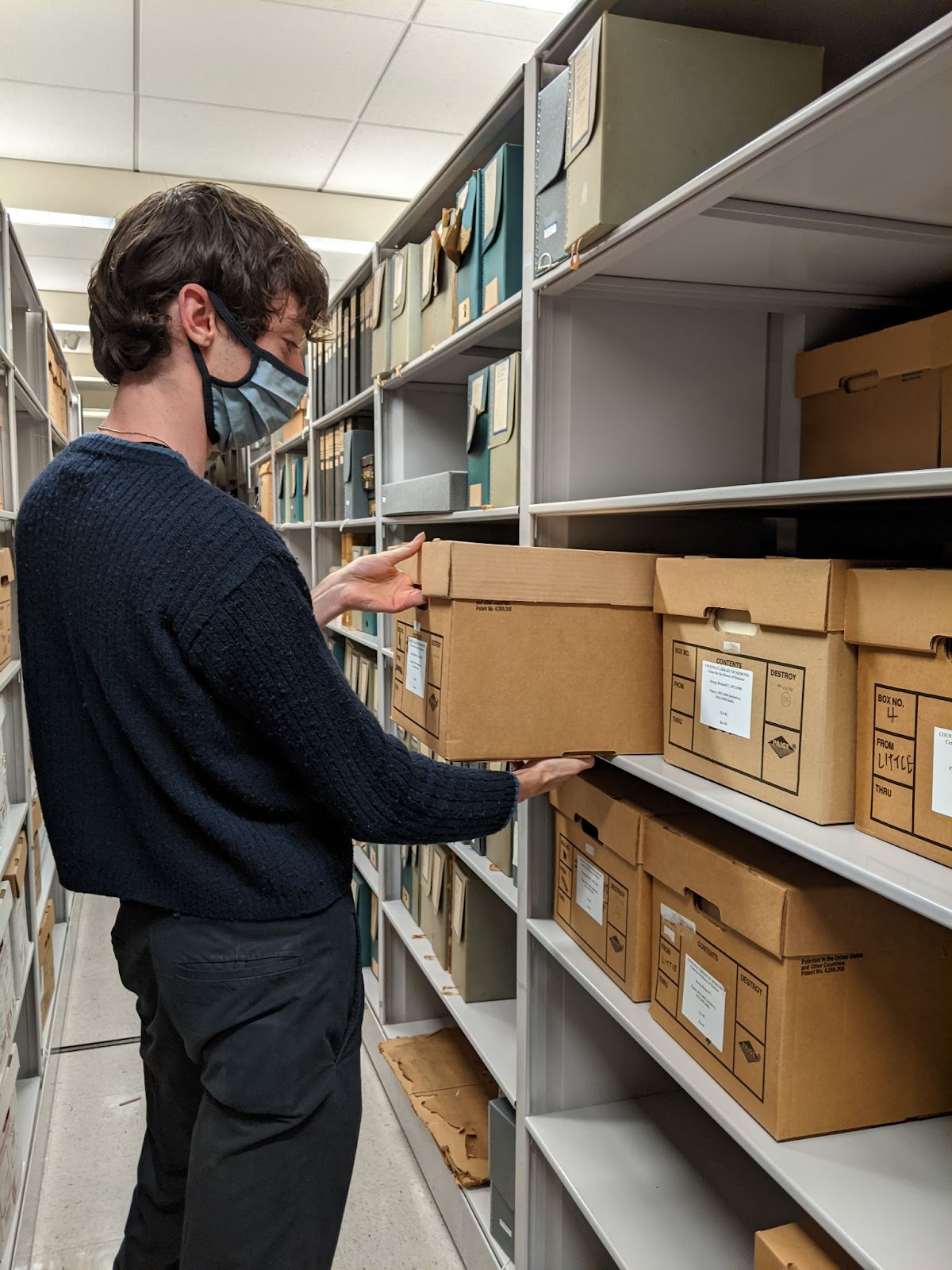 Picture of Marco re-shelving the Richard Strong Papers after adding a processing note on a file that used the term "Indian" to refer to Indigenous peoples across North, Central, and South America.