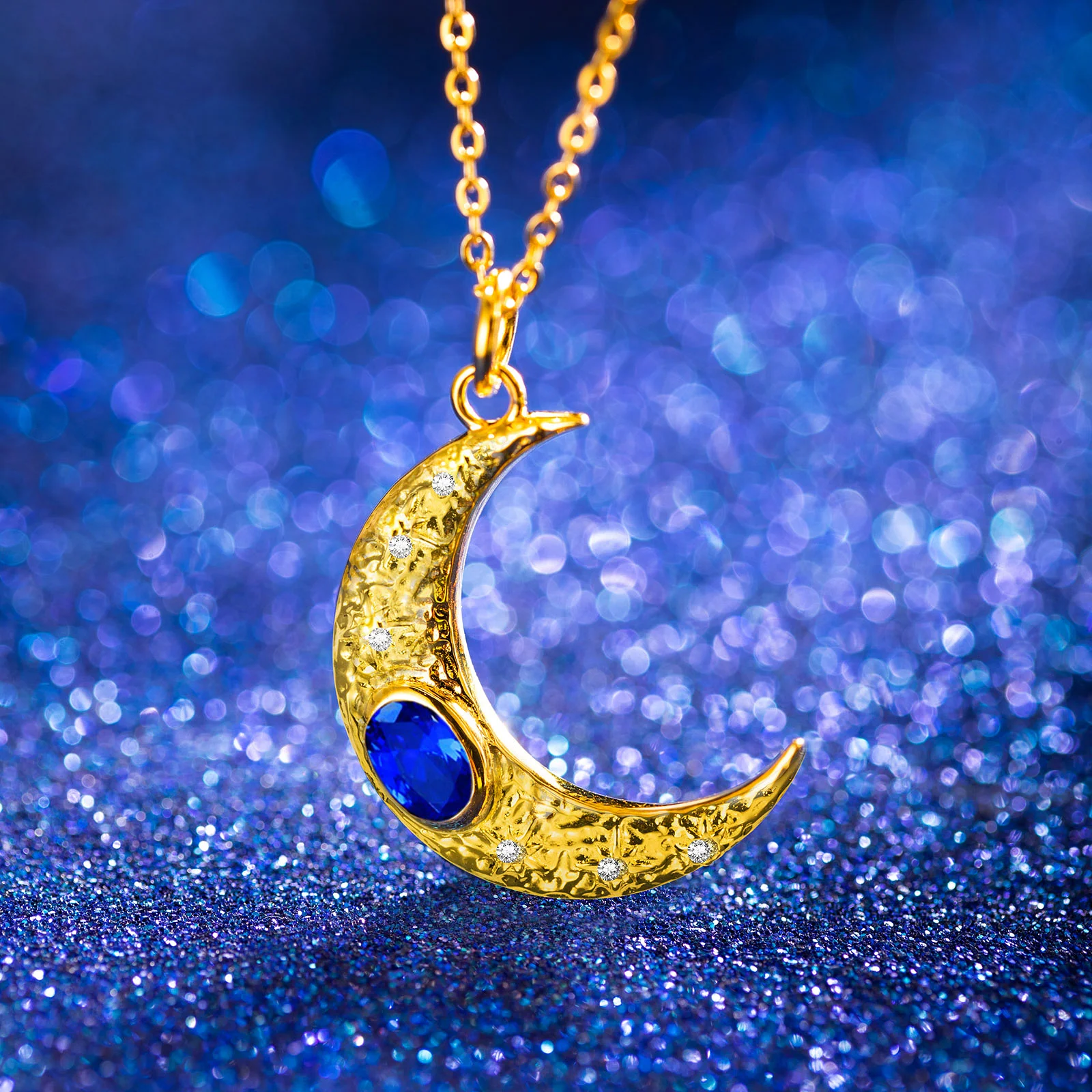 Collier en forme de croissant de lune en or, avec pierre de naissance bleue.