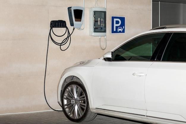 Electric car charging in parking lot ev car or electric car at charging station with the power cabl Premium Photo