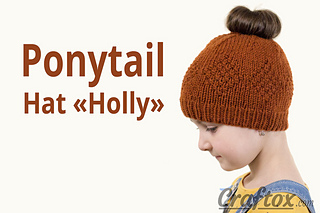 child wearing a ponytail knitted hat in front of white background