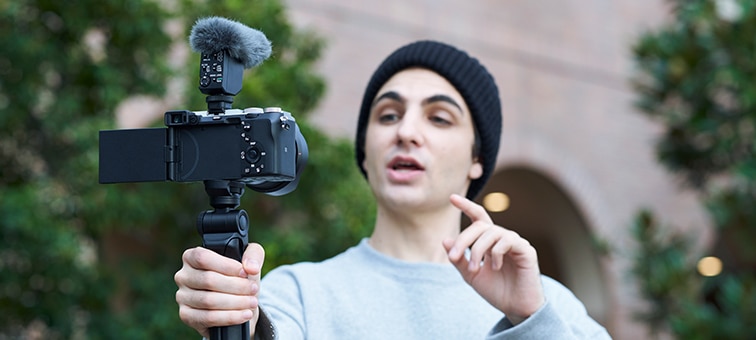 Image of a person taking a selfie in super-directional mode with the ECM-B10 attached to the camera.