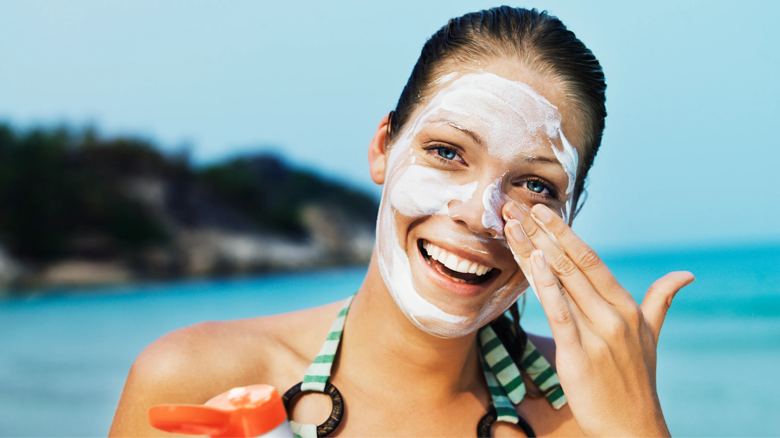 Woman putting on sunscreen and smiling