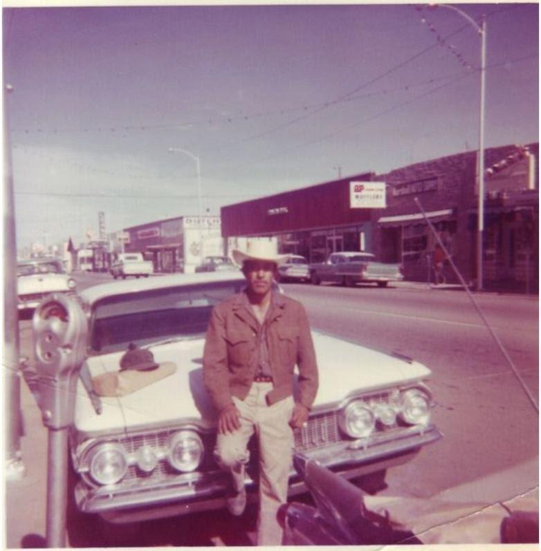 A person standing in front of a car posing for the camera

Description automatically generated