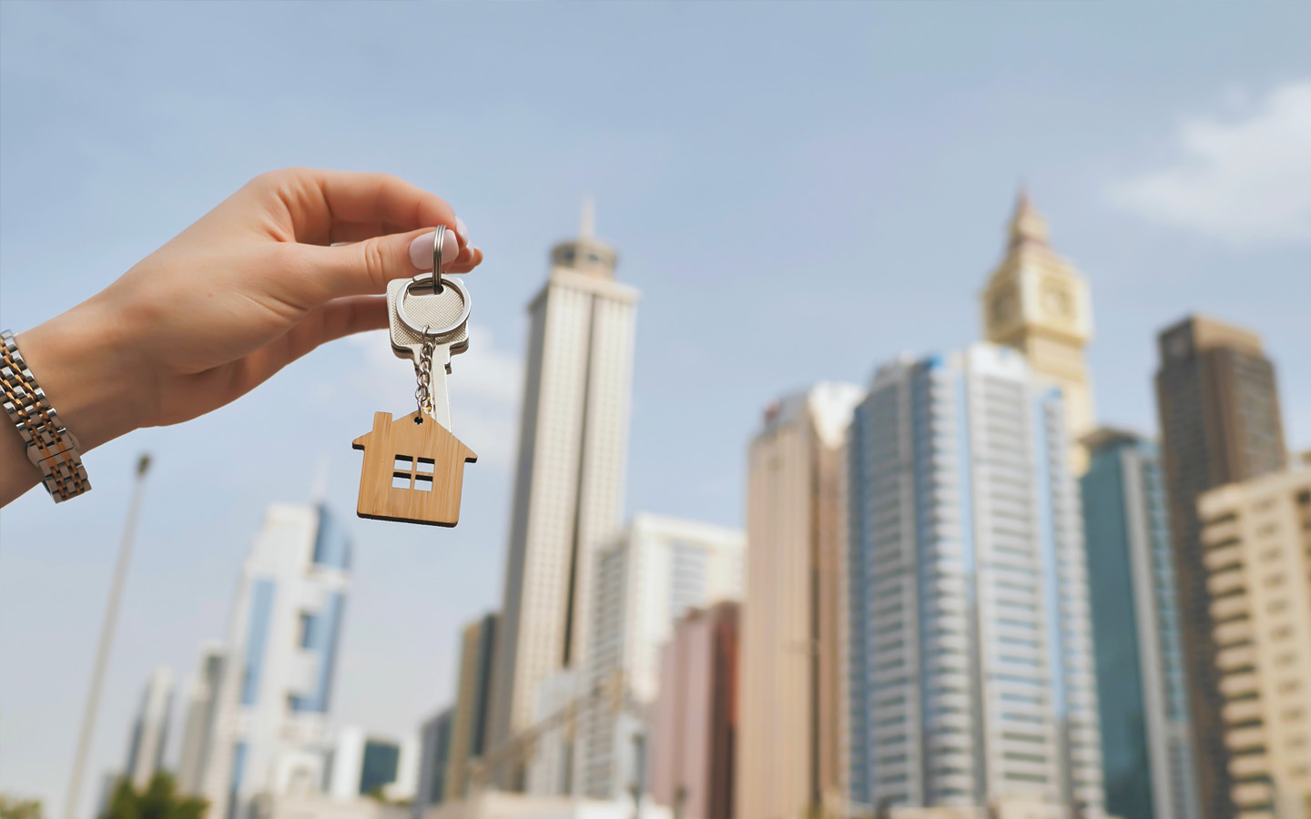 girl holding house key in front of dubai building