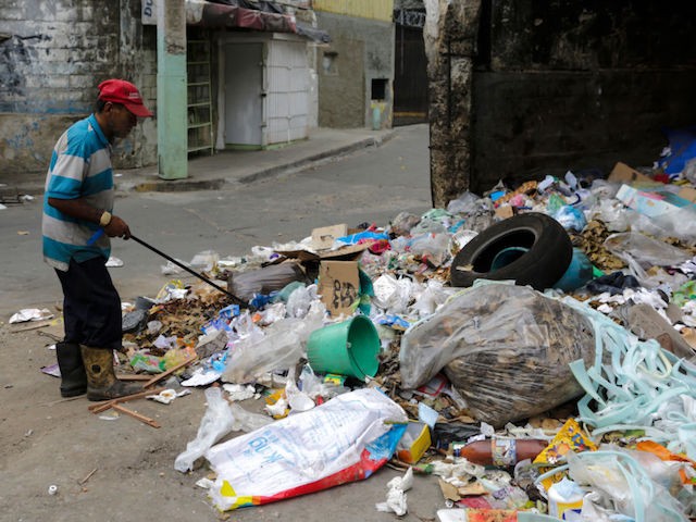 CARACAS, VENEZUELA - APRIL 10: A homeless looks for something to eat on April 10, 2019 in Caracas, Venezuela. Political and economic crisis has triggered a food emergency in Venezuela. Most supermarkets and shops do not offer a wide variety and amount of food and goods due to the shortage that affects the country. To struggle with semi empty shelves, Venezuelans have to navigate street stalls and vendors to get eggs, corn and wheat flour and rice which are the basis of the Venezuelan diet. According to the 2018 survey on life conditions ENCOVI, conducted by three local universities, 89% of people consider their incomes are not enough to afford a proper diet. Six out of 10 said they had gone to bed hungry because they did not have the money to buy food. International Monetary Found estimates a 10 million percent inflation for Venezuela in 2019 with skyrocketing rises in the price of food and goods, increasing the number of Venezuelans unable to access to a healthy nutrition. According to FAO Early Action on Food Security report 2019, Venezuela is in alert due to food insecurity and has no consistent humanitarian response plan. (Photo by Eva Marie Uzcategui/Getty Images)