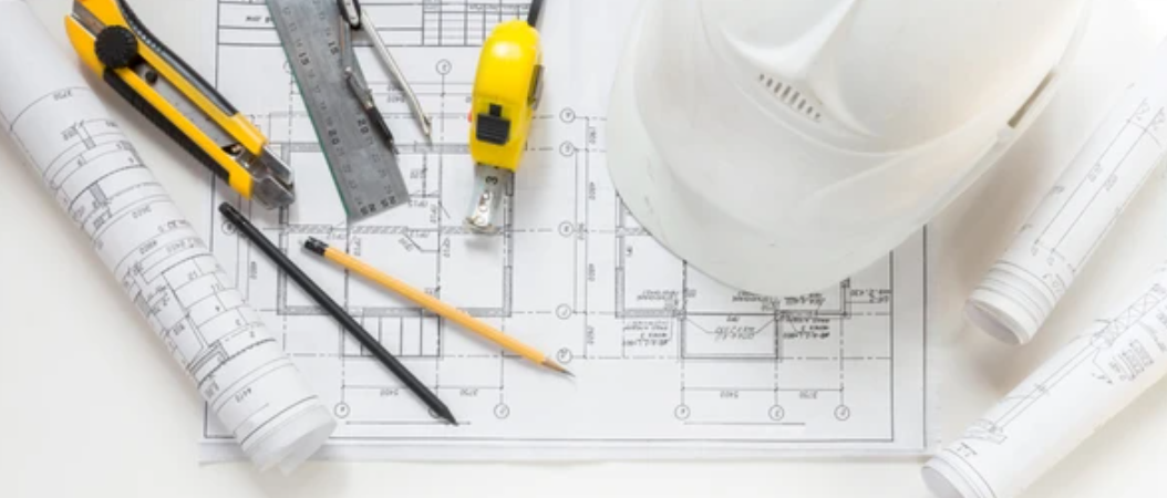 A blueprint with tools and a helmet

Description automatically generated