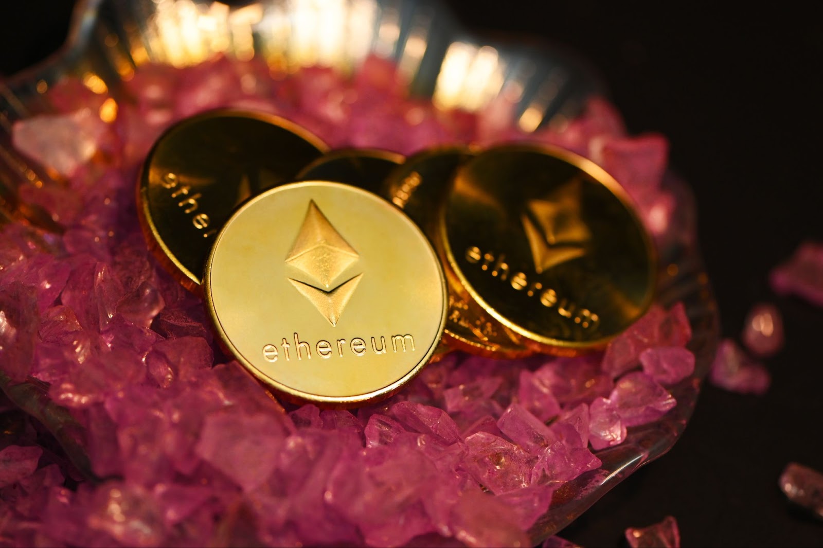 Ethereum coins in a tray with pink gemstones