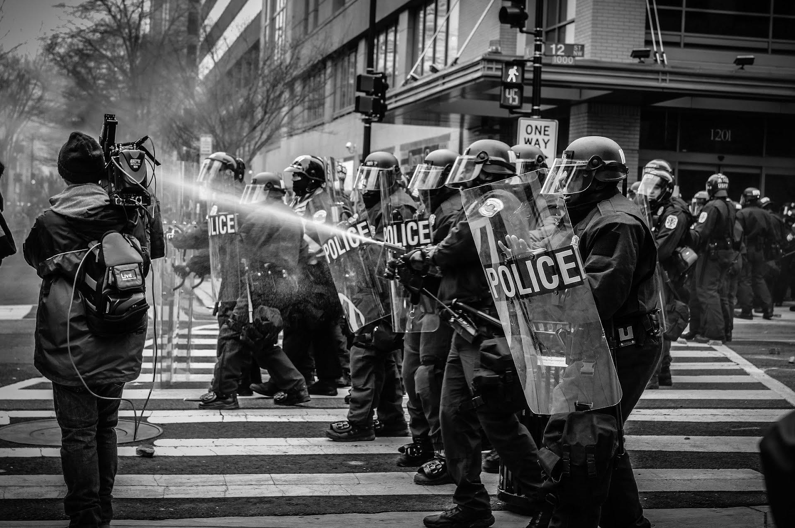 Police using water hoses at protest in city.