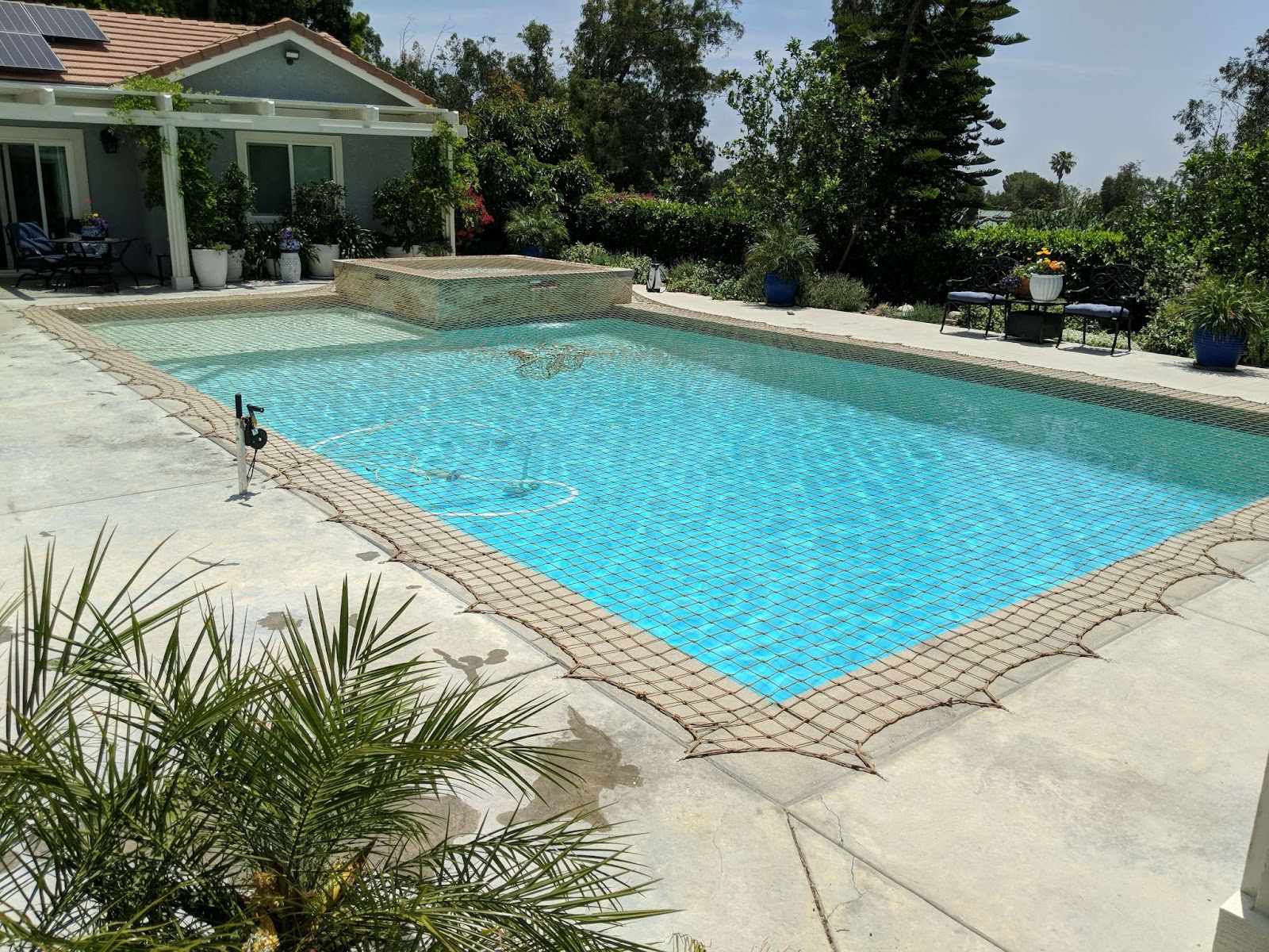 Tan pool safety net installed over a swimming pool

