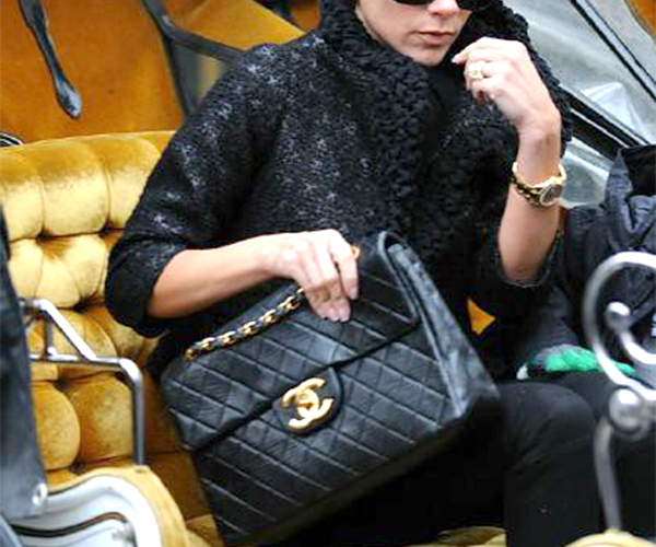 Victoria Bekham sostiene en su mano el bolso de lujo 2.55 de Chanel