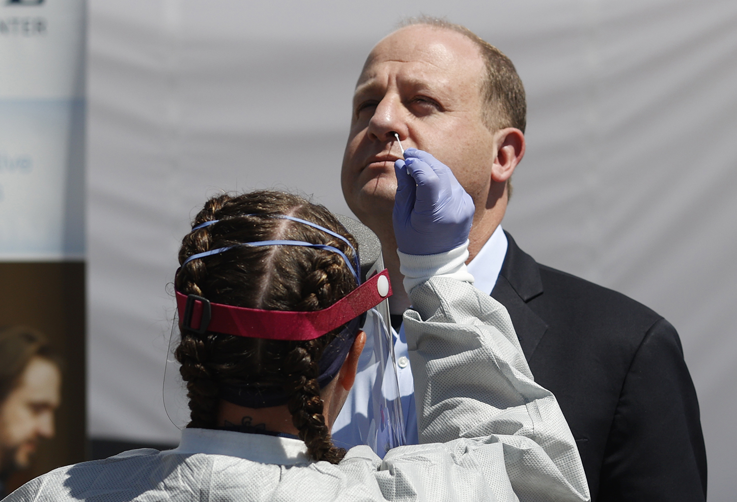 Governor Polis having a nose swab taken by a health care worker.