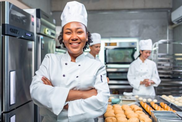 Mulher negra vestida de chef de cozinha simbolizando a transição de carreira para gastronomia