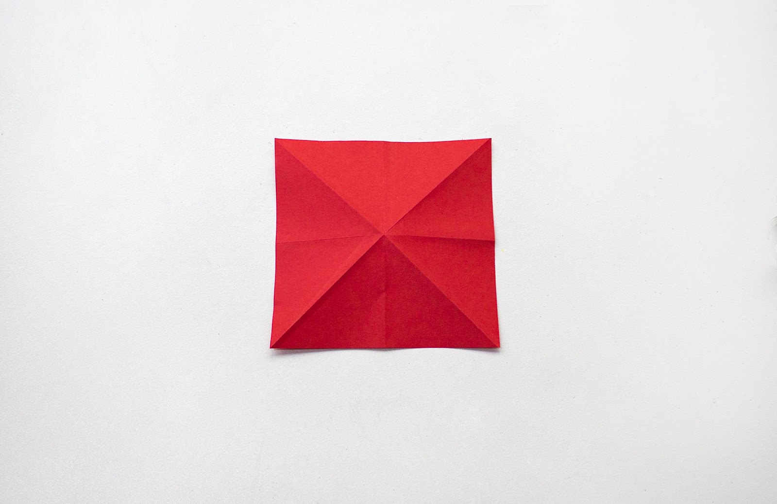 Red sheet of paper unfolded now with extra creases
