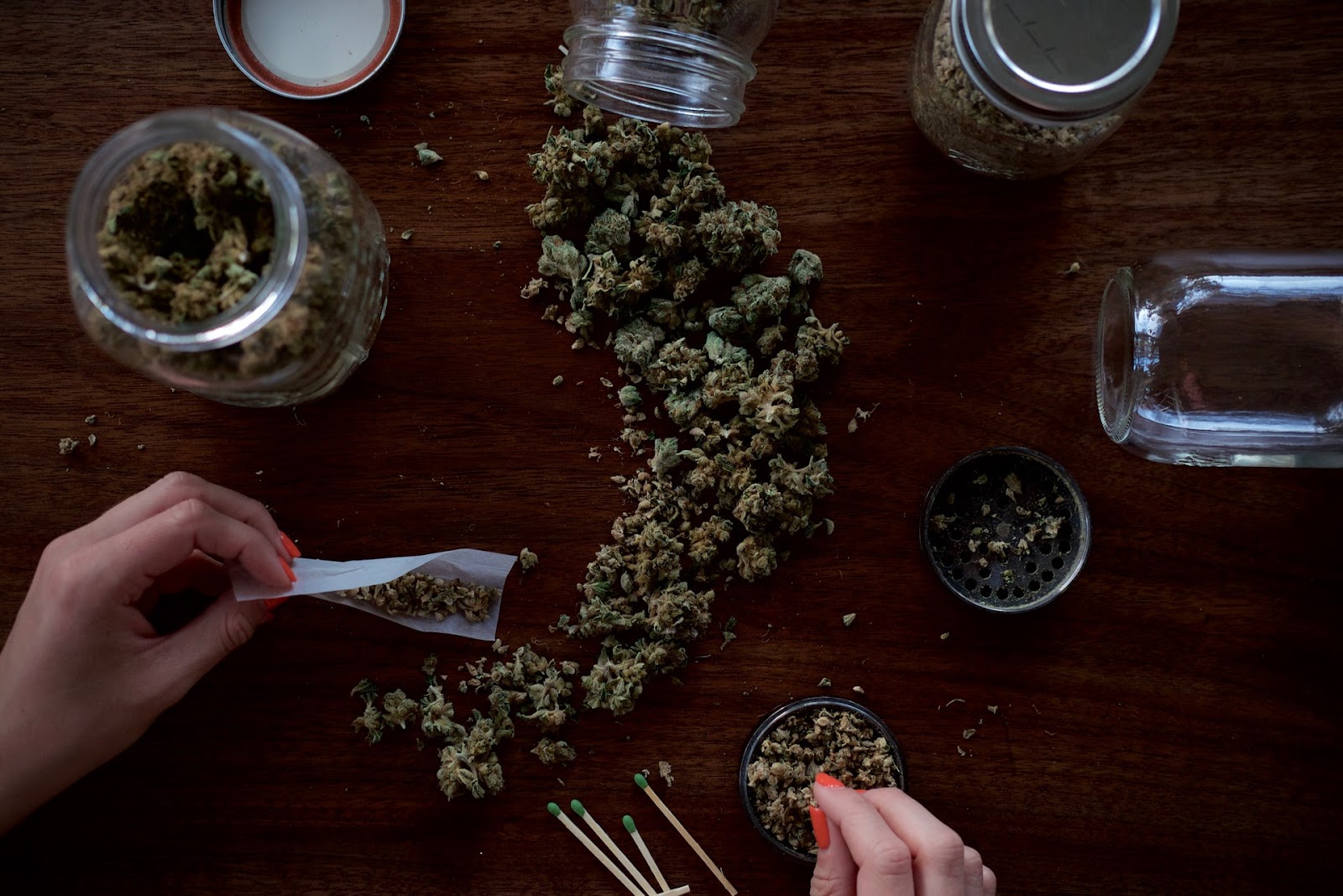 large jars of cannabis with grinder and full rolling paper