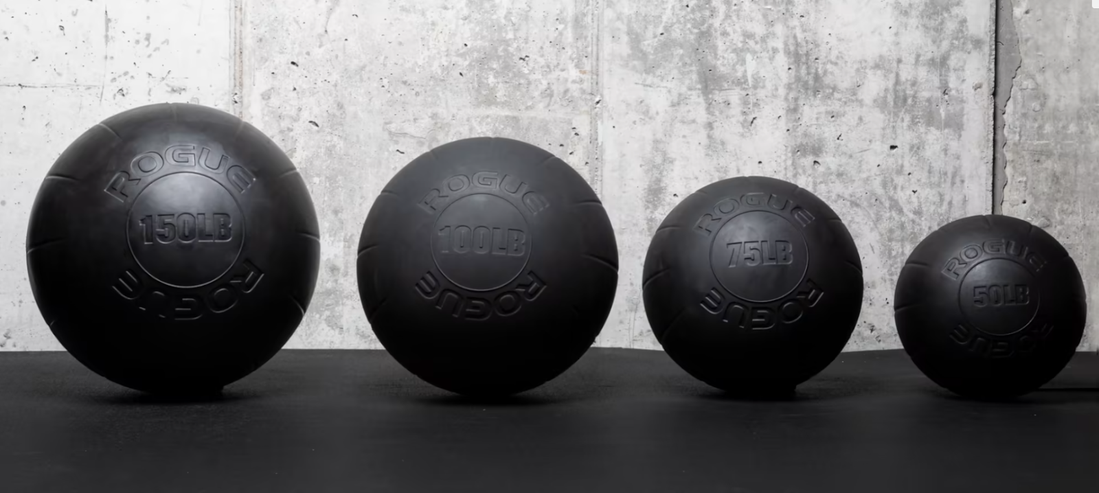An overview of the Rogue Fitness rubber atlas stones. Stones of 150lbs, 100lbs, 75lbs and 50lbs are shown.