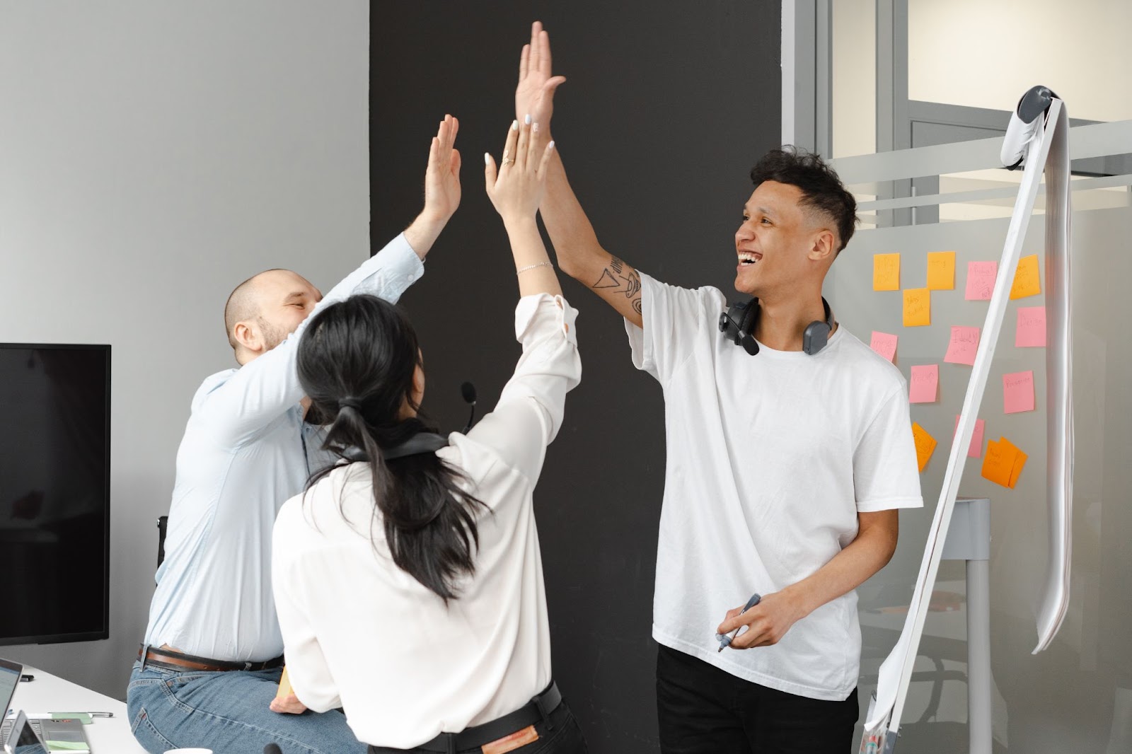 Image of a group of office workers happily high-fiving