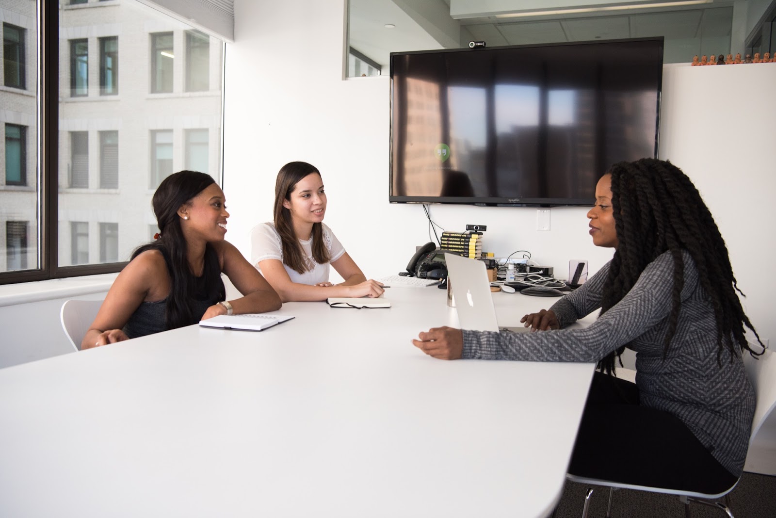 Three people in an office having an HR generalist meeting