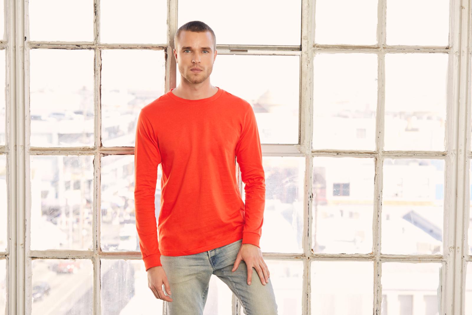 Man modeling the Bella + Canvas 3501 Unisex Jersey Long-Sleeve T-Shirt in the color “poppy” 