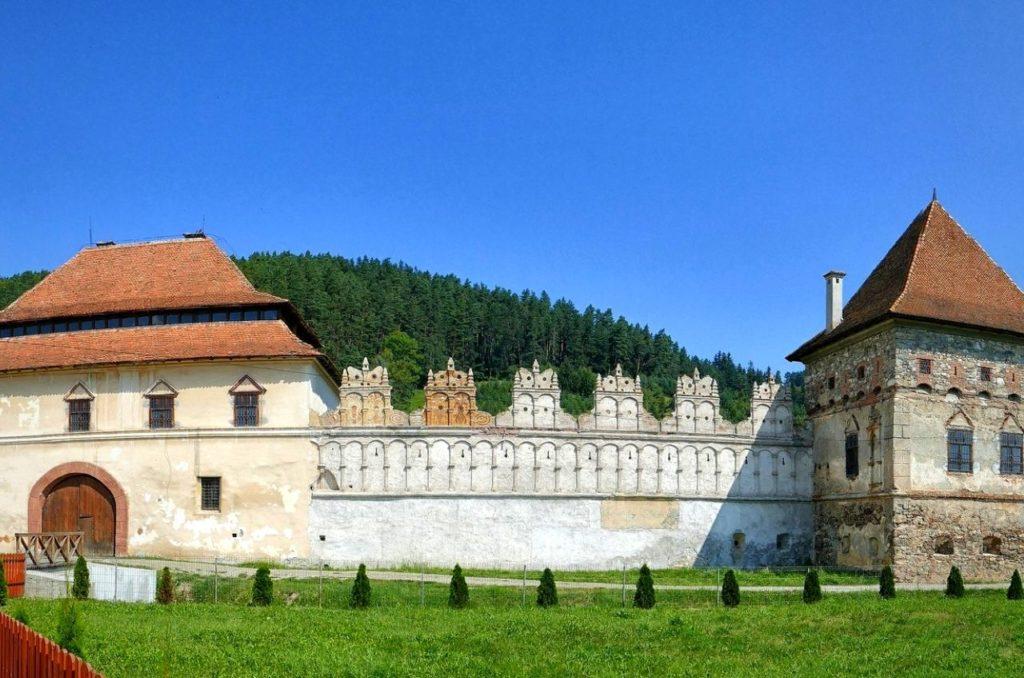Red roofs and white outer facade of Lazar Castle, one of the most incredible Transylvanian castles to visit.