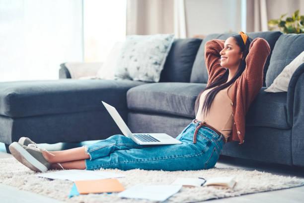 To live your best, find your balance Shot of a young woman relaxing while working in the living room at home tax filing happienss stock pictures, royalty-free photos & images
