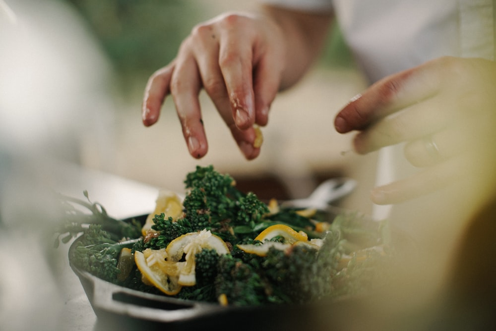 selective focus photography of green and orange vegetables on black container